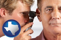 texas an audiologist examining the ear of a patient